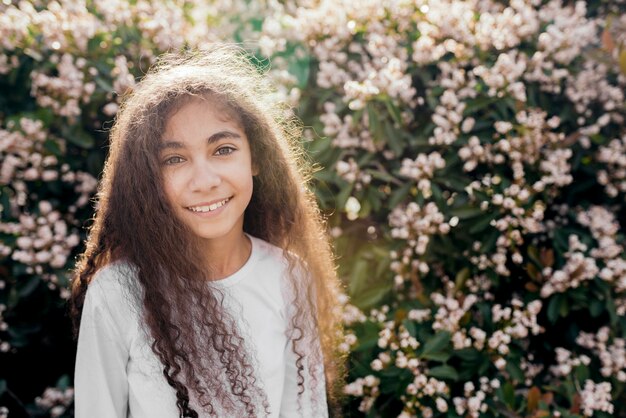 Retrato de una muchacha bonita sonriente en luz del sol