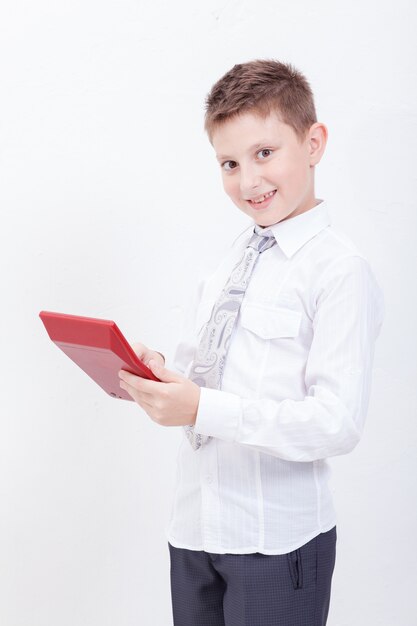 Retrato de muchacho adolescente con calculadora en pared blanca