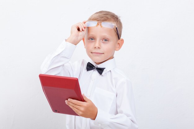 Retrato de muchacho adolescente con calculadora sobre fondo blanco.