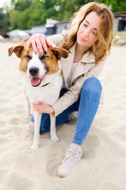 Retrato de mujer acariciando a su perro en el parque