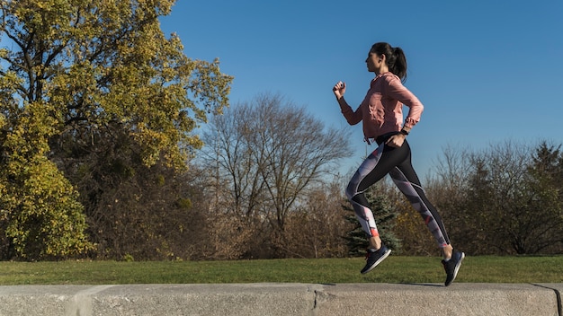 Retrato de mujer activa corriendo al aire libre