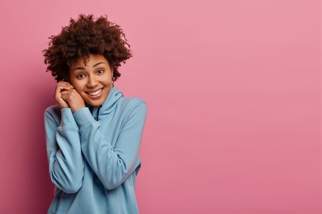 Retrato de mujer adolescente feliz con pelo rizado Afro, sonríe sinceramente