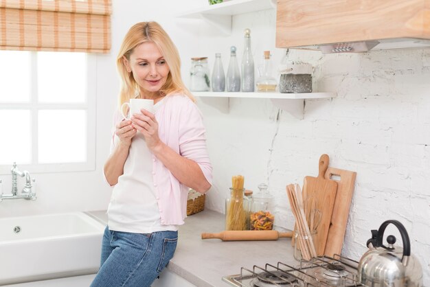 Retrato de mujer adulta disfrutando de café en casa