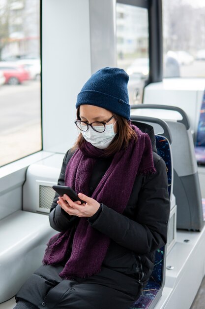 Retrato de mujer adulta con máscara quirúrgica en transporte público