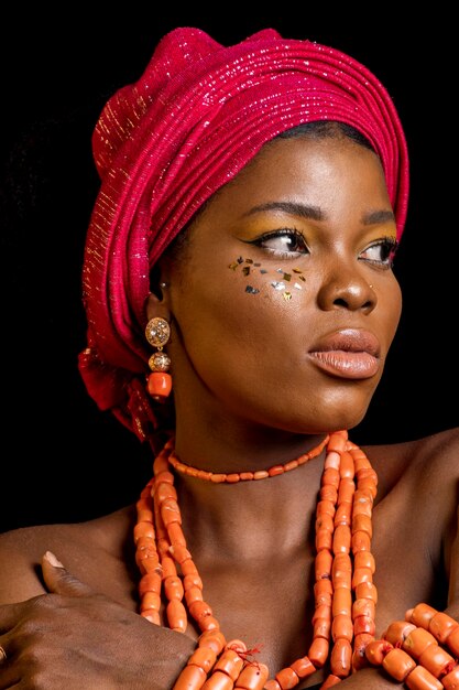 Retrato de mujer africana con accesorios tradicionales y apartar la mirada