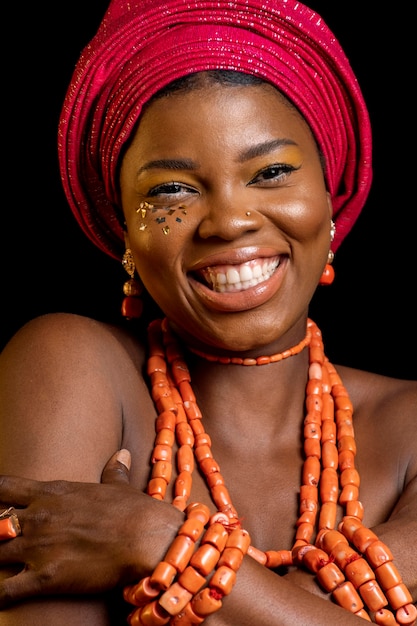 Retrato de mujer africana vistiendo accesorios tradicionales sonriendo