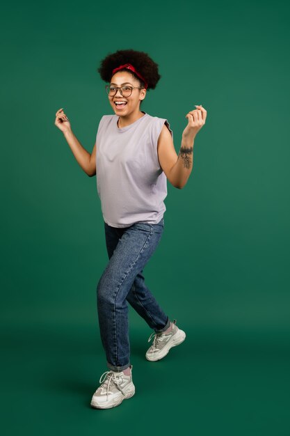 Retrato de mujer afroamericana aislado en pared verde con copyspace