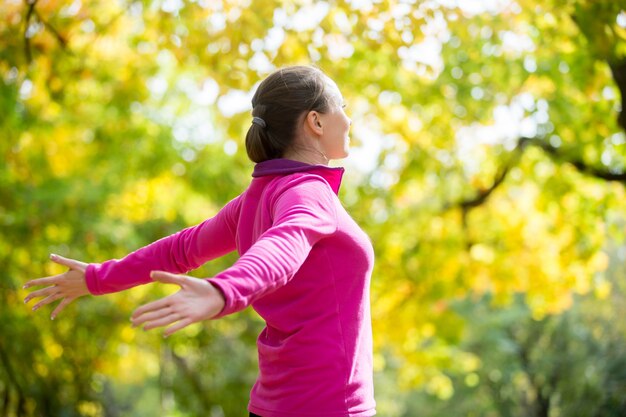 Retrato de una mujer al aire libre en una ropa deportiva, manos outstreched