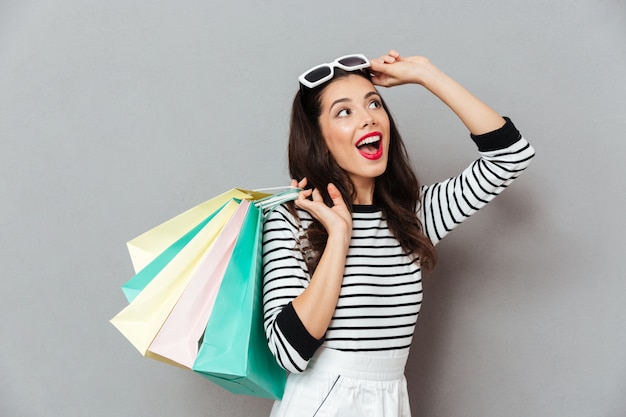 Foto gratuita retrato de una mujer alegre con bolsas de compras