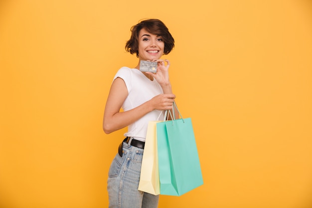 Retrato de una mujer alegre sonriente sosteniendo bolsas de compras