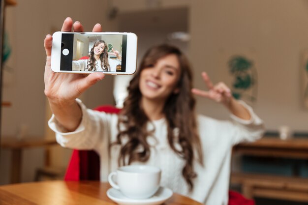 Retrato de una mujer alegre tomando una selfie