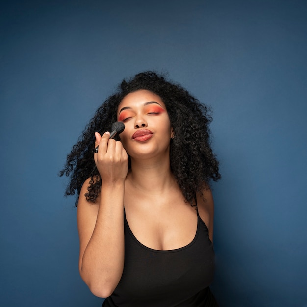 Retrato de una mujer aplicando maquillaje con un pincel de maquillaje