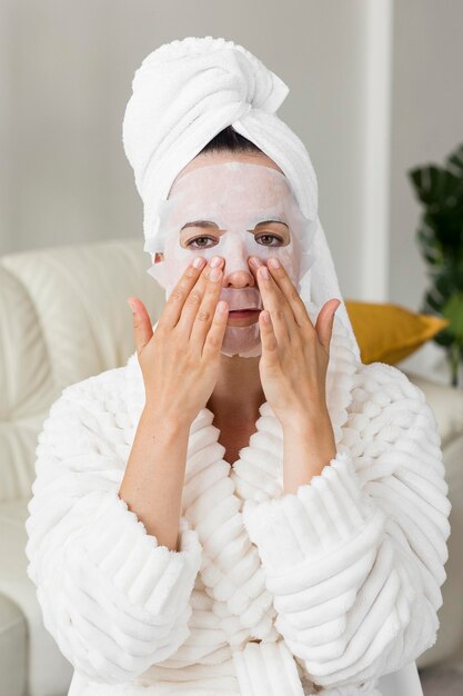 Retrato de mujer aplicando mascarilla facial