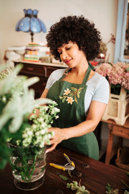 Retrato de una mujer arreglando flores en la tienda