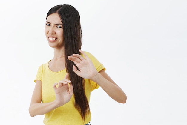 Foto gratuita retrato de mujer arrogante y malhumorada disgustada levantando las palmas para protegerse de lo repugnante