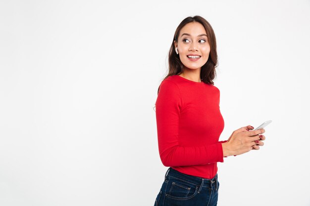 Retrato de una mujer asiática contenta alegre en auriculares