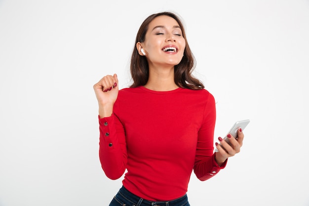 Retrato de una mujer asiática feliz contenta en auriculares