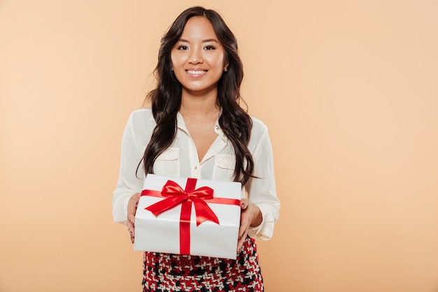 Retrato de una mujer asiática feliz mostrando caja de regalo