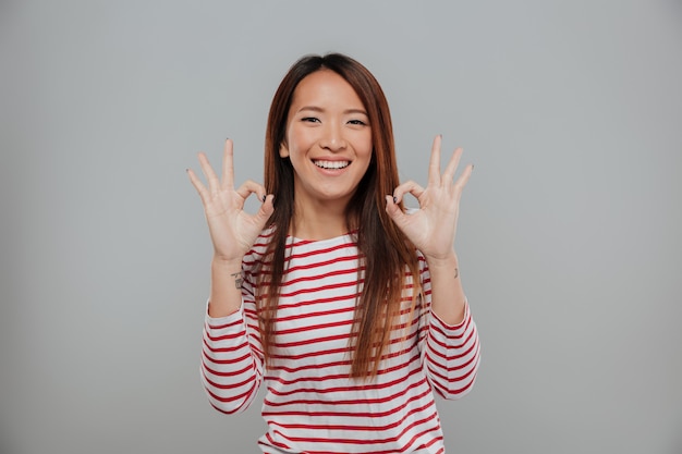 Foto gratuita retrato de una mujer asiática feliz mostrando gesto bien