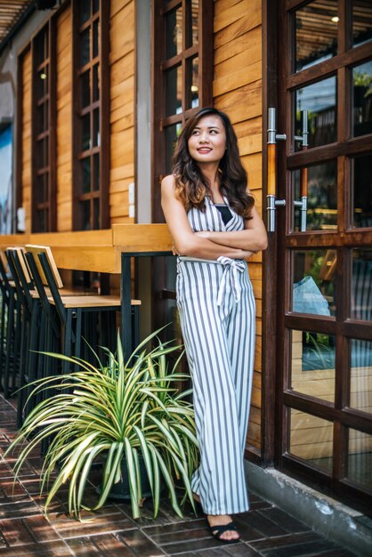 El retrato de la mujer asiática hermosa se relaja en el café