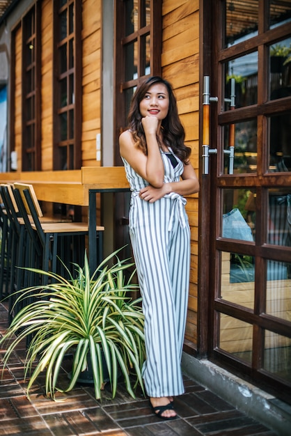 El retrato de la mujer asiática hermosa se relaja en el café