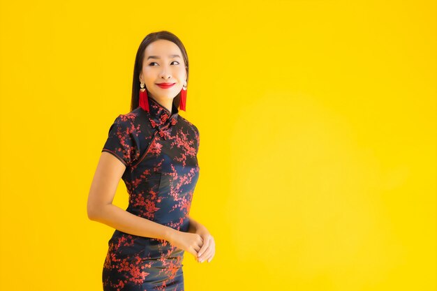 El retrato de la mujer asiática joven hermosa viste el vestido chino y sonríe