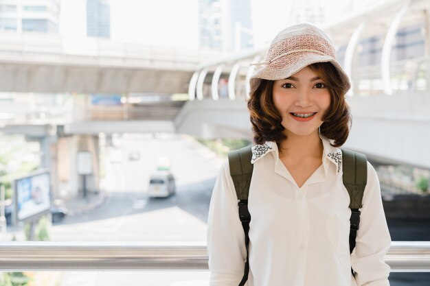 Retrato de mujer asiática sonriente joven atractiva al aire libre en la ciudad