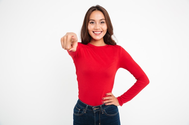 Retrato de una mujer asiática sonriente que señala el dedo a la cámara