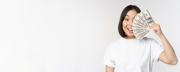 Foto gratuita retrato de mujer asiática sonriente sosteniendo dólares concepto de dinero de financiación de microcréditos y efectivo standi