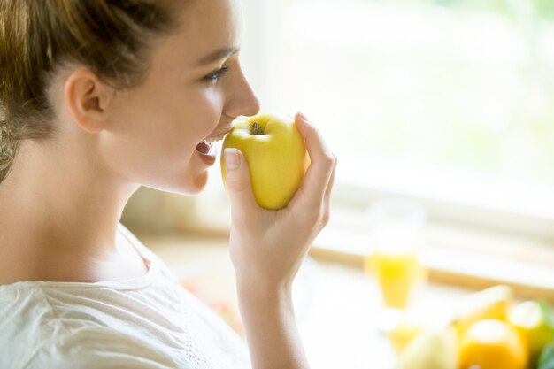 Retrato de una mujer atractiva comer una manzana