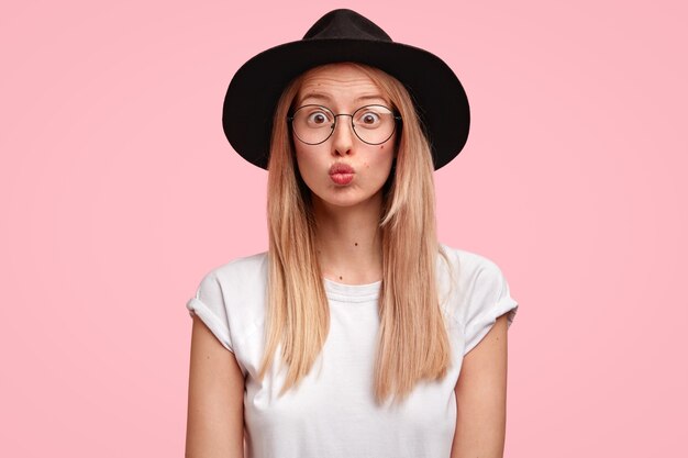 Retrato de mujer atractiva con gafas y gran sombrero negro