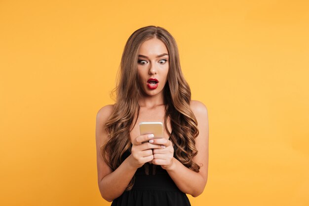 Retrato de mujer atractiva sorprendida en vestido negro