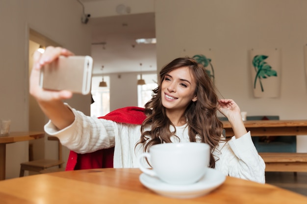 Retrato de una mujer atractiva tomando una selfie