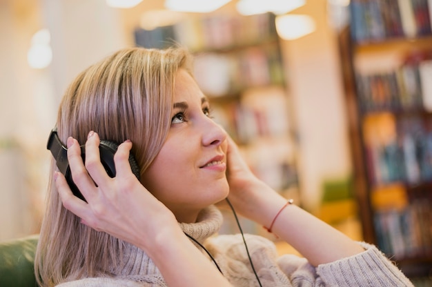 Retrato de mujer con auriculares mirando hacia arriba