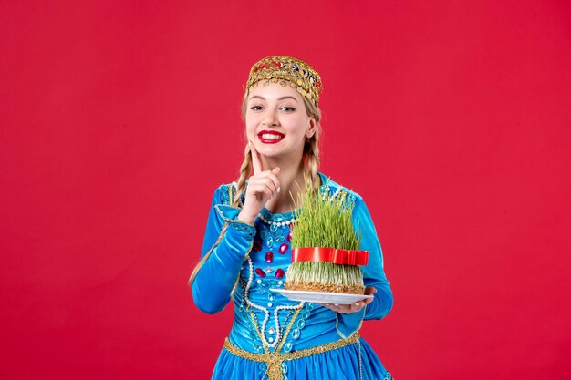 Retrato de mujer azerí en traje tradicional con estudio semeni disparó fondo rojo concepto de vacaciones primavera novruz