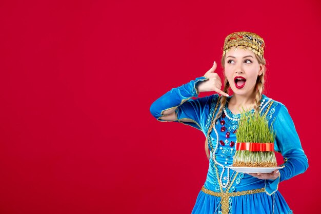 Retrato de mujer azerí en traje tradicional con estudio semeni verde filmado sobre fondo rojo colores étnicos de primavera novruz