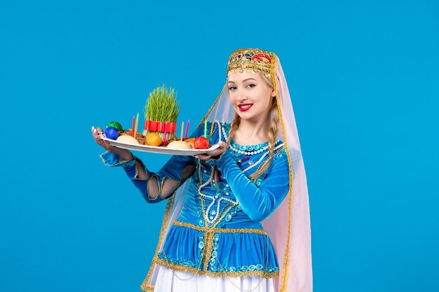 Retrato de mujer azerí en traje tradicional con novruz xonca estudio disparó fondo azul primavera étnica