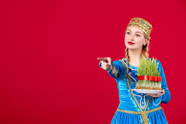 Retrato de mujer azerí en traje tradicional con semeni verde sobre fondo rojo concepto bailarina étnica primavera