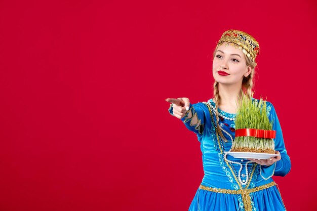 Retrato de mujer azerí en traje tradicional con semeni verde sobre fondo rojo concepto bailarina étnica primavera