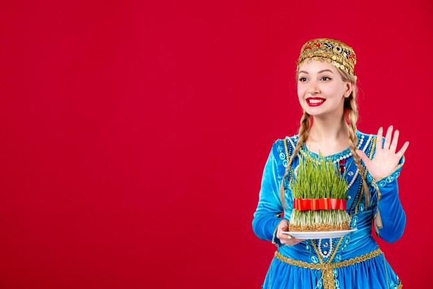 Retrato de mujer azerí en traje tradicional con semeni verde sobre fondo rojo concepto étnico bailarina novruz
