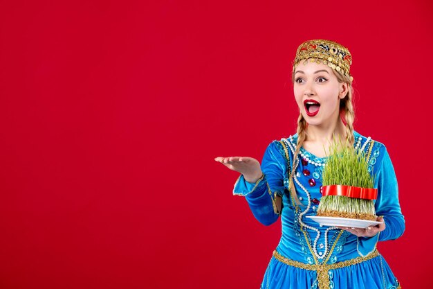 Retrato de mujer azerí en traje tradicional con semeni verde sobre fondo rojo concepto étnico novruz bailarina primavera