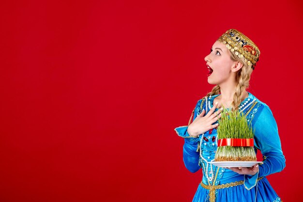 Retrato de mujer azerí en traje tradicional con semeni verde sobre fondo rojo concepto primavera novruz