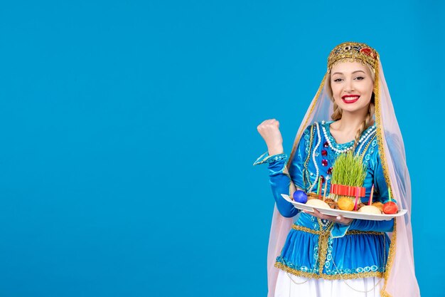 Retrato de mujer azerí en traje tradicional con xonca sobre fondo azul concepto de primavera novruz bailarines étnicos