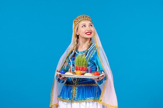 Retrato de mujer azerí en traje tradicional con xonca studio shot fondo azul colores de bailarina de primavera étnica novruz