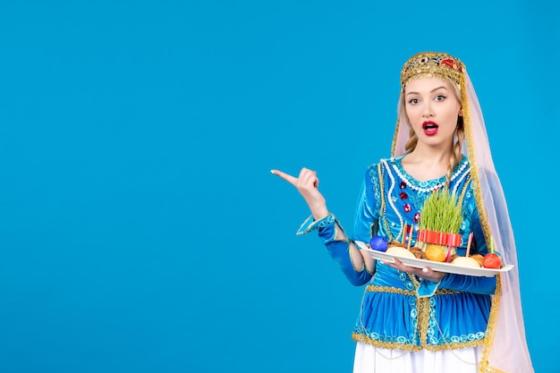 Retrato de mujer azerí en traje tradicional con xonca studio shot fondo azul concepto bailarina étnica primavera