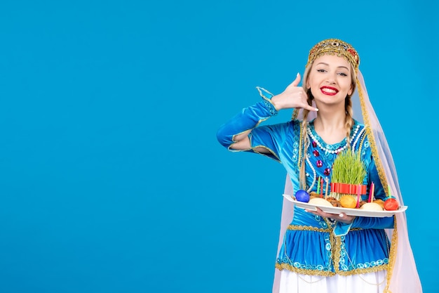 Retrato de mujer azerí en traje tradicional con xonca studio shot fondo azul concepto bailarina primavera novruz foto étnica