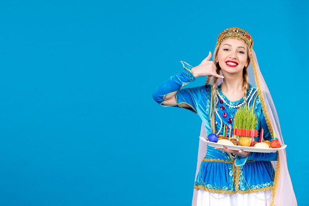 Retrato de mujer azerí en traje tradicional con xonca studio shot fondo azul concepto bailarina primavera novruz foto étnica