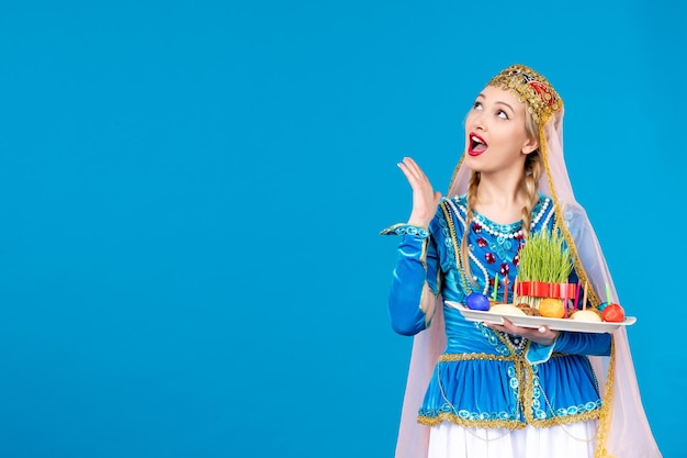 Retrato de mujer azerí en traje tradicional con xonca studio shot fondo azul concepto bailarina primavera novruz