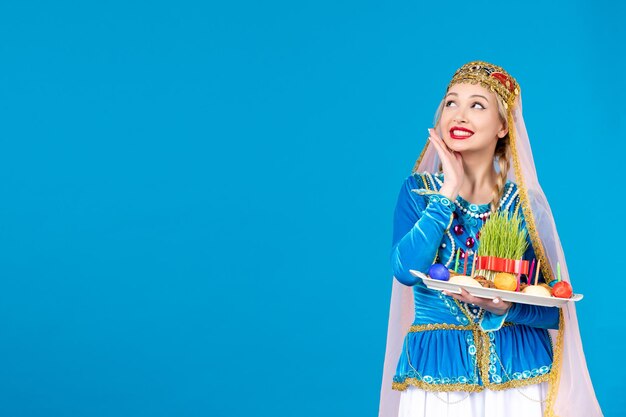 Retrato de mujer azerí en traje tradicional con xonca studio shot fondo azul concepto de primavera bailarina étnica