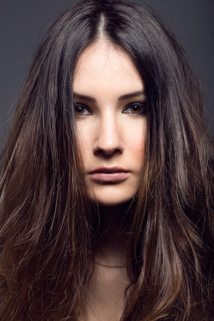 Retrato de la mujer bastante joven que presenta en la foto del estudio.